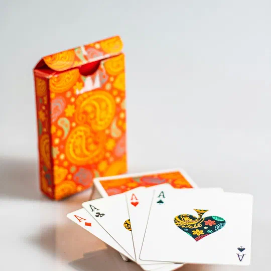 A printed deck of playing cards fanned in front of its tuck box