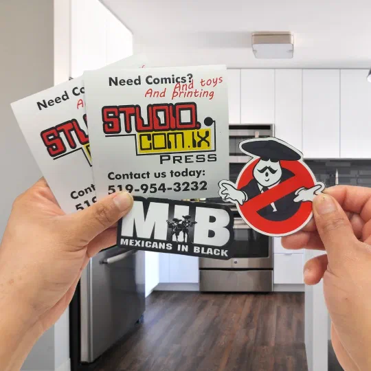 Printed fridge magnets held in two hands, including two die-cut character magnets